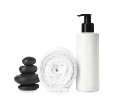 Beyaz arka planda bir şişe kozmetik ürünü, havlu ve spa taşı.