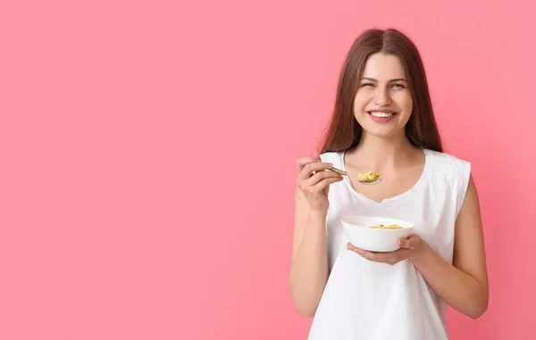 Junge Frau Und Schale Mit Cornflakes Auf Farbigem Hintergrund — Stockfoto