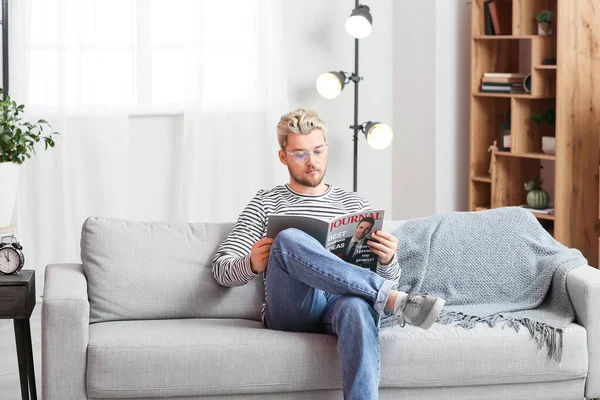 Young Man Wearing Glasses While Reading Magazine Home — Stock Photo, Image