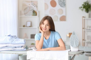 Evinde temiz çamaşırları olan güzel genç bir kadın.