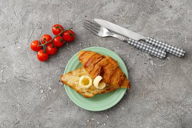 Taze kruvasan, tereyağı ve domatesli kompozisyon.