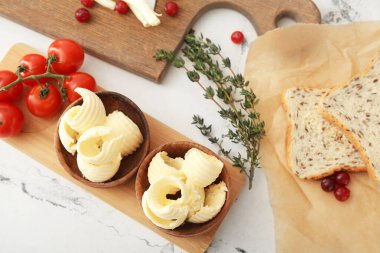 Taze tereyağlı, domatesli ve arka planda biberiyeli kompozisyon