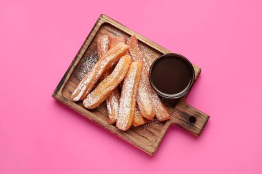 Lezzetli churros ve eritilmiş çikolata soslu tahta.