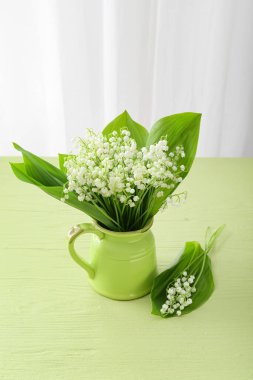 Vadideki güzel çiçekli sürahi renkli masada.