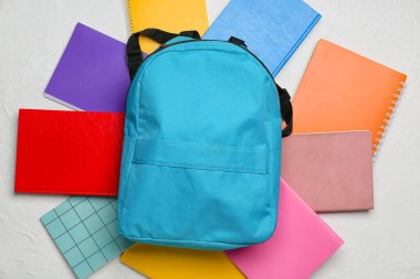 Okul çantası ve ışık arkaplanı üzerine not defterleri