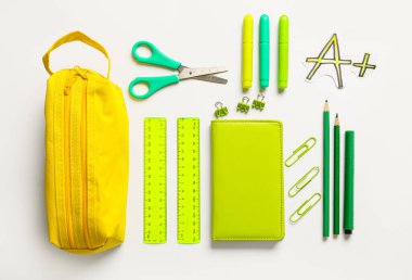 Beyaz arkaplanda kalem kutusu ve kırtasiye malzemesi