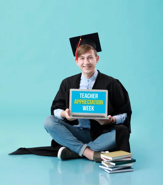 Male graduating student holding laptop with text TEACHER APPRECIATION WEEK on screen against color background