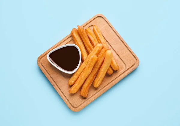 Board Tasty Churros Melted Chocolate Sauce Color Background — Stock Photo, Image