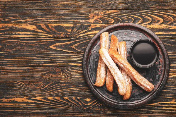 Plate Tasty Churros Melted Chocolate Sauce Wooden Background — Stock Photo, Image