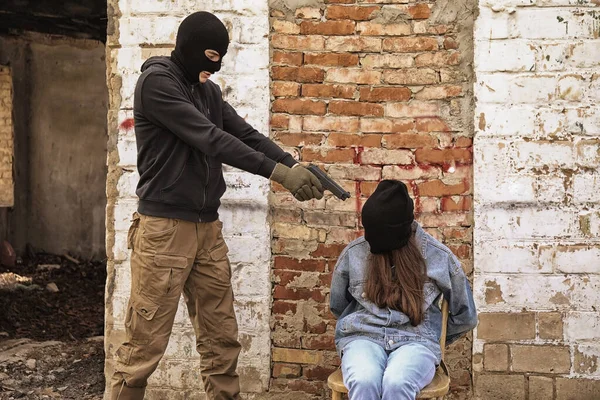 Terrorist Aiming Female Hostage Outdoors —  Fotos de Stock