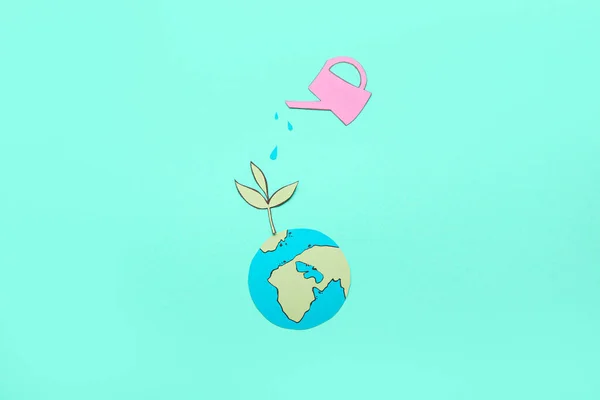 Papierplanet Erde Mit Grüner Pflanze Und Gießkanne Auf Farbigem Hintergrund — Stockfoto