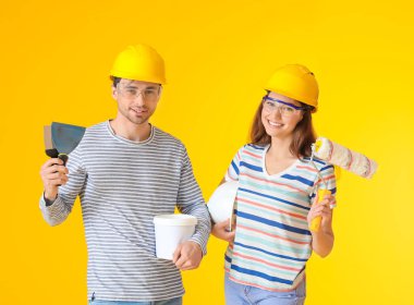 Renk arkaplanında tamir araçları olan genç çift