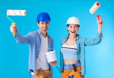 Arka planda boya ve silindirli genç bir çift.