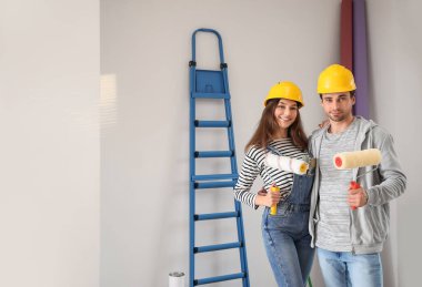 Yeni evlerinde boya rulosu olan mutlu bir çift.