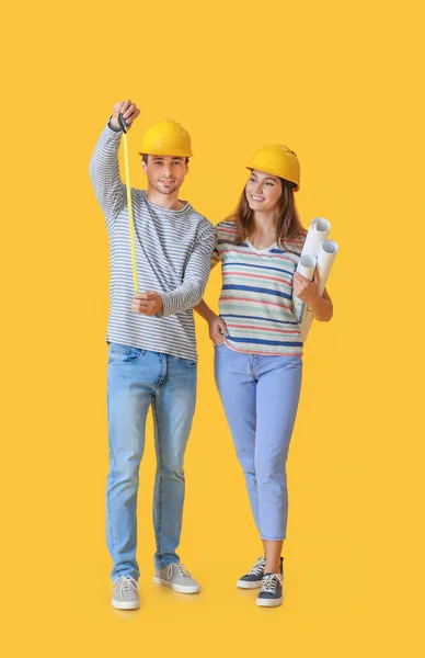 Pareja Joven Con Planos Casa Cinta Métrica Sobre Fondo Color — Foto de Stock