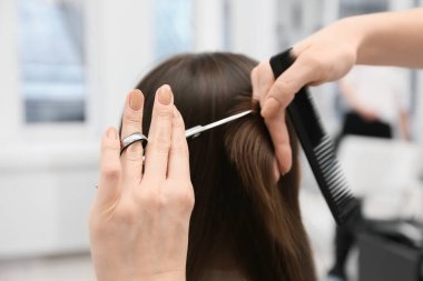 Güzellik salonunda saç kesen kadın kuaför, yakın plan.
