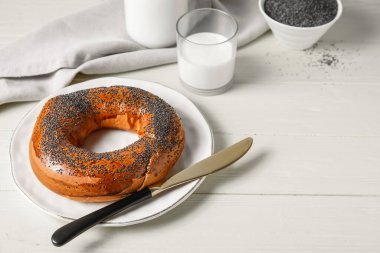 Hafif ahşap arka planda haşhaş tohumlu simit.