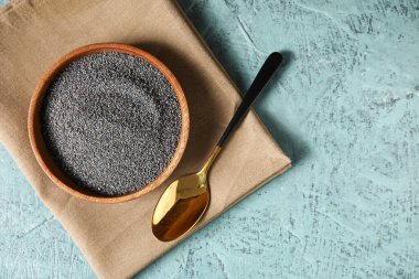 Renkli arkaplanda haşhaş tohumlu tabak ve kaşık