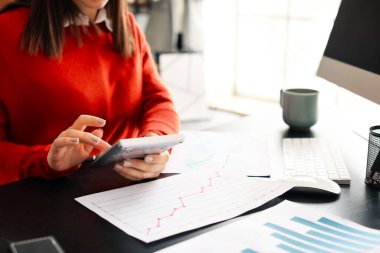 Hesap makineli kadın muhasebeci ofiste çalışıyor, yakın plan.