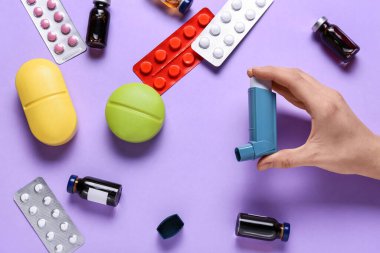 Spreyli kadın eli ve renk arkaplanındaki ilaçlar