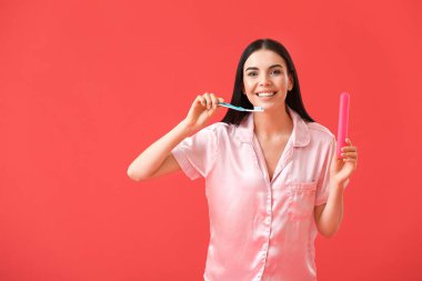 Renkli arka planda dişlerini fırçalayan güzel kadın.