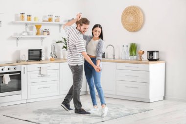 Mutfakta dans eden mutlu genç çift.