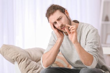 Evde kavga üstüne kavga çıkaran alyanslı genç bir adam.