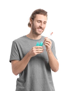 Beyaz arka planda diş fırçası olan yakışıklı bir adam.