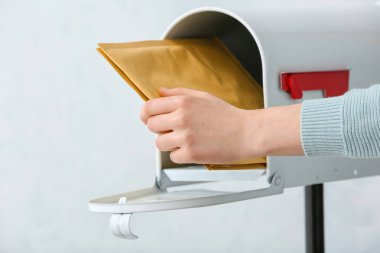 Kadın ışık arkaplanındaki kutudan mektuplar alıyor