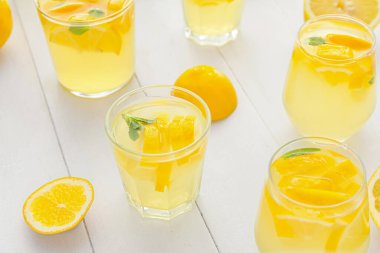 Hafif ahşap arka planda lezzetli soğuk limonata bardakları