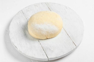 Beyaz zemin üzerinde taze hamur ve un olan tahta