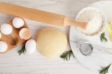 Hafif ahşap zemin üzerinde taze hamur, un ve yumurta.