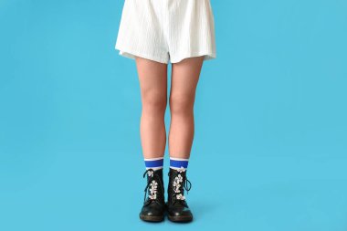 Ayakkabılarında bahar çiçekleri olan güzel bir genç kadın.