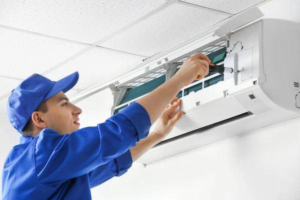 Young Electrician Repairing Air Conditioner Indoors — Stock Photo, Image