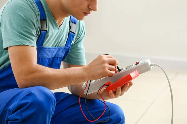 Young Electrician Measuring Voltage Extension Cord Room — Stock Photo, Image