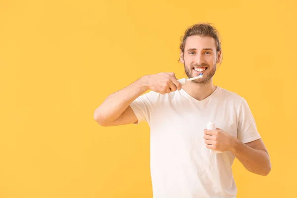 Junger Mann Beim Zähneputzen Auf Farbigem Hintergrund — Stockfoto