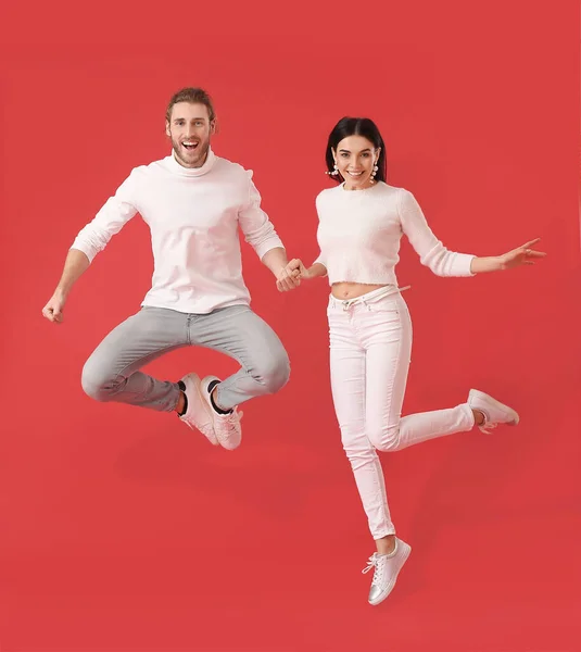 Feliz Joven Pareja Saltando Sobre Fondo Color — Foto de Stock