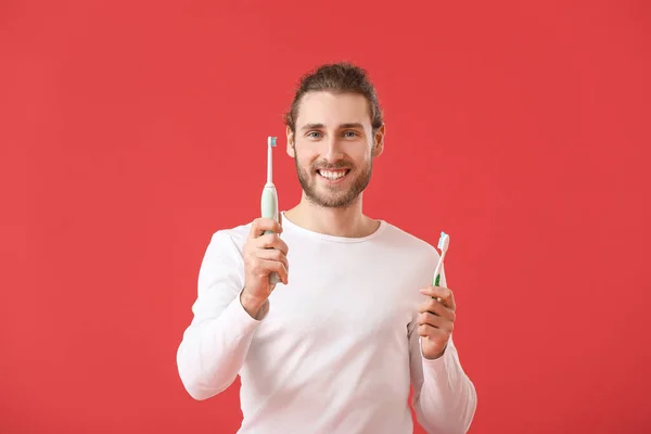 Knappe Man Met Tandenborstels Kleur Achtergrond — Stockfoto