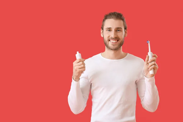Schöner Mann Mit Zahnbürste Und Paste Auf Farbigem Hintergrund — Stockfoto