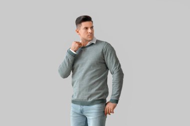 Gri arka planda şık bir genç adam.