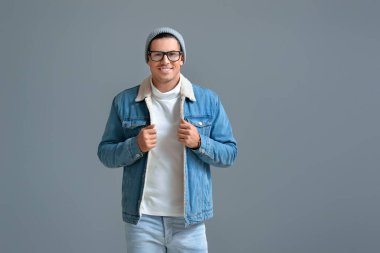 Gri arka planda şık bir genç adam.