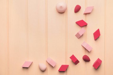 Renkli ahşap arka planda makyaj süngeri