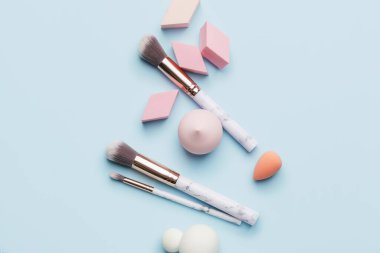 Renk arkaplanında fırça bulunan makyaj süngerleri