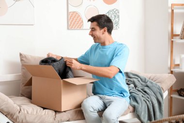 Evde kıyafetlerle dolu kutuları açan genç adam şaşırdı.