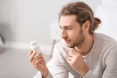 Evde hapları olan yakışıklı bir genç.