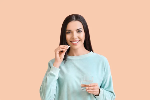 Hermosa Mujer Joven Tomando Pastillas Fondo Color —  Fotos de Stock