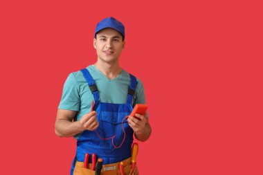 Renk arka planında çokölçere sahip genç elektrikçi