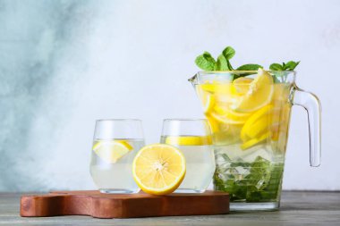 Hafif arka planda bir sürahi ve lezzetli soğuk limonata.