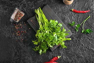 Taze maydanozlu pano ve koyu arkaplanda baharatlar.