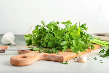 Taze maydanozlu pano ve hafif arka planda sarımsak.